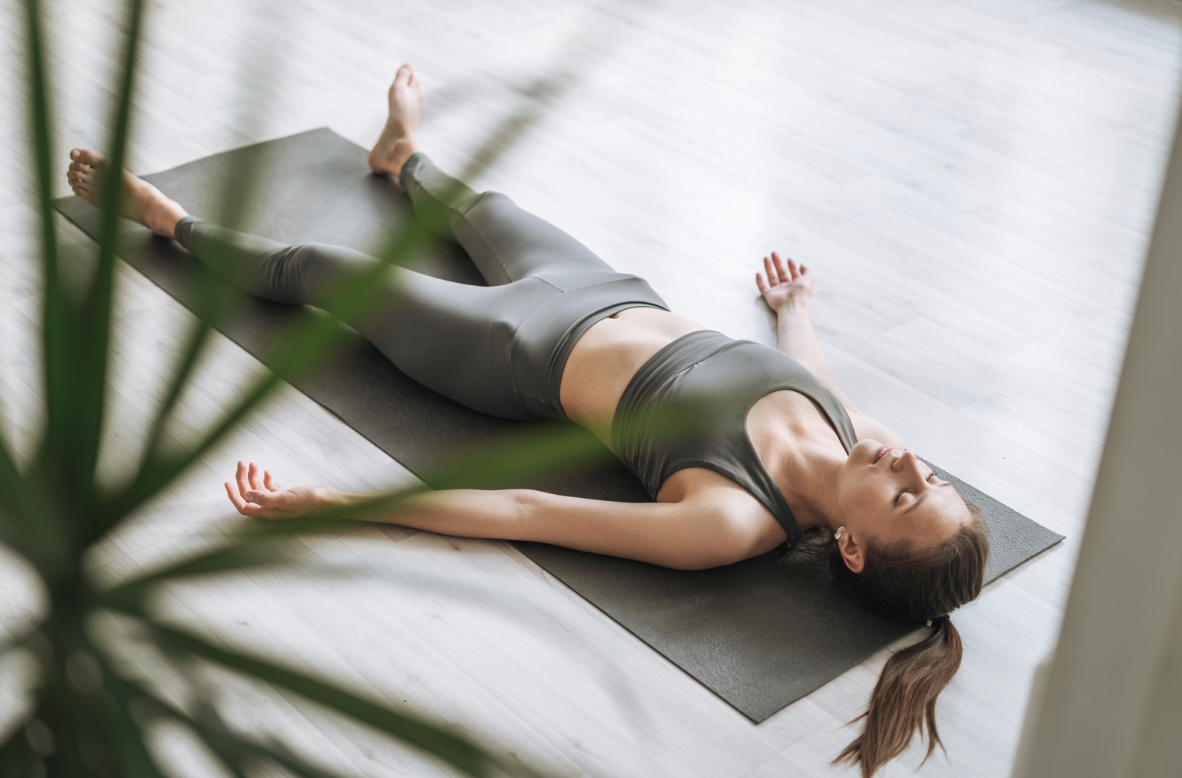 Image shows women laying on a mat practicing Progressive Muscle Relaxation demonstrating the benefits of Progressive Muscle Relaxation for improving sleep and reducing stress.